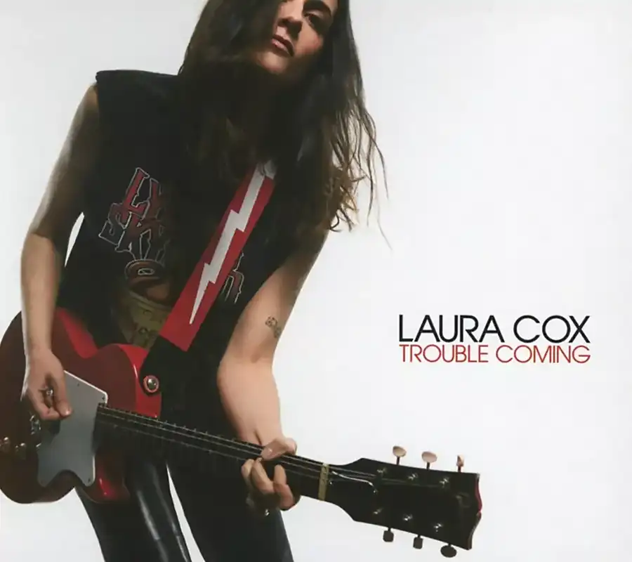 Trouble Coming de Laura Cox, 2025, Laura, Guitare rouge à la main, tout de noir vêtu, sur fond blanc de la pochette