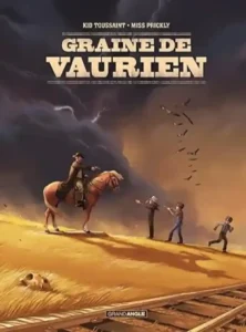 Kid Toussaint, ITW en 2026, couverture de la BD, un personnage à cheval tient en joug 3 autres dont un qui semble s'enfuir, une voie ferrée derrière ceux-ci, dans une ambiance chaude, style western, des vautours au loin dans un ciel menaçant.